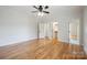 Bright bedroom featuring hardwood floors, a ceiling fan, and doorways to a closet and other rooms at 20635 Queensdale Dr, Cornelius, NC 28031