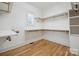Walk-in closet features built-in shelving, storage space, wood floor and natural light at 20635 Queensdale Dr, Cornelius, NC 28031