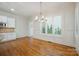 Dining room with hardwood floors, a chandelier, wainscoting, and large windows with views at 20635 Queensdale Dr, Cornelius, NC 28031