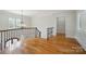 Upstairs hallway boasts hardwood floors, chandelier, staircase, and plenty of natural light at 20635 Queensdale Dr, Cornelius, NC 28031