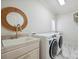 Well-lit laundry room features white washer and dryer units, a sink, and marble floors at 20635 Queensdale Dr, Cornelius, NC 28031