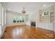Bright living room showcasing hardwood floors, fireplace, built-in shelving and many windows at 20635 Queensdale Dr, Cornelius, NC 28031