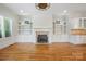 This living room features hardwood floors, a fireplace, built-in shelving, and kitchen access at 20635 Queensdale Dr, Cornelius, NC 28031