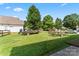 Spacious backyard with lush green grass, featuring a trailer, boat, and mature trees at 219 Mccord St, Charlotte, NC 28216