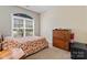 Comfortable bedroom with a window view, featuring a floral bedspread and wooden dresser at 219 Mccord St, Charlotte, NC 28216