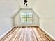 Finished attic space featuring vaulted ceilings, a window, and wood-look flooring at 2242 Shumard Cir, Indian Trail, NC 28079