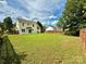 Spacious backyard featuring a lawn, wooden fence, and yellow house at 2242 Shumard Cir, Indian Trail, NC 28079