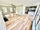 Bright, open living area with light wood flooring, ceiling fan, fireplace, and access to the kitchen at 2242 Shumard Cir, Indian Trail, NC 28079