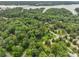 Lush aerial view of a wooded residential area showcasing mature trees, winding roads, and a glimpse of a nearby lake at 23 Tanglewood Rd, Clover, SC 29710