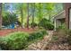 Lush backyard featuring a stone pathway, blue Adirondack chairs, and mature trees at 23 Tanglewood Rd, Clover, SC 29710