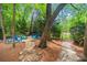 Landscaped backyard with a stone path, blue Adirondack chairs, and a fire pit at 23 Tanglewood Rd, Clover, SC 29710