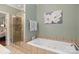 Bathroom featuring a bathtub and shower with tiled walls and a decorative flower painting at 23 Tanglewood Rd, Clover, SC 29710