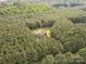 Scenic aerial shot shows the house set in a clearing amidst dense woodland at 237 Garvin Rd, McConnells, SC 29726