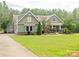 Charming two-story home featuring manicured lawn, lush landscaping, and inviting curb appeal in a wooded neighborhood at 237 Garvin Rd, McConnells, SC 29726