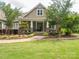 Inviting front porch with stone accents, a walkway through manicured garden beds, and mature trees at 237 Garvin Rd, McConnells, SC 29726