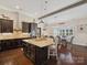 Kitchen with dark cabinets, granite counters, stainless appliances and an island with seating overlooking the dining room at 237 Garvin Rd, McConnells, SC 29726