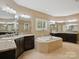 Bright main bathroom featuring soaking tub, double vanity with granite countertops and tile flooring at 237 Garvin Rd, McConnells, SC 29726