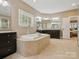 Bright main bathroom featuring soaking tub, double vanity with granite countertops, separate shower and tile flooring at 237 Garvin Rd, McConnells, SC 29726