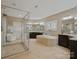 Bright main bathroom featuring soaking tub, glass enclosed shower, double vanity and tile flooring at 237 Garvin Rd, McConnells, SC 29726
