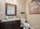 Powder room featuring dark wood vanity with granite countertop, toilet, decorative shelving and framed mirror at 237 Garvin Rd, McConnells, SC 29726