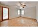 Bright bedroom featuring hardwood floors, ceiling fan, two windows, and deck access at 25056 Timberlake Dr, Fort Mill, SC 29708
