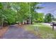 Long, private driveway leading to a home surrounded by lush greenery and mature trees at 25056 Timberlake Dr, Fort Mill, SC 29708