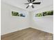 Bright bedroom featuring wood-look flooring, a ceiling fan, and ample natural light through the windows at 2600 Alleghany St # 10, Charlotte, NC 28208