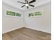 Sunlit bedroom with wood-look flooring, modern ceiling fan, and ample natural light through large windows at 2600 Alleghany St # 10, Charlotte, NC 28208