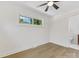 Bright bedroom featuring wood-look floors, a ceiling fan, and a doorway leading to the bathroom at 2600 Alleghany St # 10, Charlotte, NC 28208