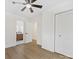 Spacious bedroom with wood-look flooring, featuring a ceiling fan and doors leading to a closet and bathroom at 2600 Alleghany St # 10, Charlotte, NC 28208