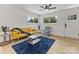 Bright living room with a yellow sofa, a dark blue rug, and hardwood floors at 2600 Alleghany St # 10, Charlotte, NC 28208