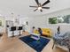 Bright living room with a yellow sofa, a dark blue rug, and hardwood floors at 2600 Alleghany St # 10, Charlotte, NC 28208