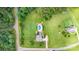 An aerial view shows a lushly landscaped property with a pool, home, surrounding greenery, and adjacent road at 3068 Green Acres Ln, Claremont, NC 28610