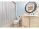 Cozy bathroom featuring a vanity with a round mirror and a shower with a striped curtain at 3068 Green Acres Ln, Claremont, NC 28610