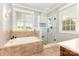 Bathroom featuring a soaking tub, glass-enclosed shower, and bright window at 3068 Green Acres Ln, Claremont, NC 28610