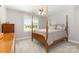 Bedroom with a four-poster bed, gray carpet, and view of the backyard at 3068 Green Acres Ln, Claremont, NC 28610