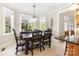 A dining room displays large windows, tile flooring, and a decorative dark wood table with padded chairs at 3068 Green Acres Ln, Claremont, NC 28610