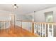Upstairs hallway with hardwood floors, white railings and sunlit windows at 3068 Green Acres Ln, Claremont, NC 28610