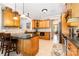 Spacious kitchen with wooden cabinetry, granite countertops, tile flooring, and breakfast bar at 3068 Green Acres Ln, Claremont, NC 28610