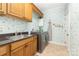 The laundry room shows a new washer and dryer, cabinetry, and playful wallpaper at 3068 Green Acres Ln, Claremont, NC 28610