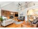 Open living room with cathedral ceiling, stone fireplace, built-in shelving, and hardwood floors at 3068 Green Acres Ln, Claremont, NC 28610