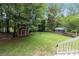 Lush backyard with mature trees, two sheds, and a well-manicured lawn at 3092 Hitching Post Ln, Rock Hill, SC 29732