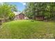Expansive backyard with lush grass, a fire pit, and a storage shed at 3092 Hitching Post Ln, Rock Hill, SC 29732
