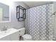Well-lit bathroom featuring a white vanity, toilet, and shower with a patterned curtain at 3092 Hitching Post Ln, Rock Hill, SC 29732