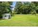 Large backyard featuring a shed, wood fence, and mature trees at 322 Cottonwood Park Dr, Charlotte, NC 28214