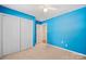 Bright blue bedroom featuring neutral carpet, a ceiling fan, and a double door closet at 322 Cottonwood Park Dr, Charlotte, NC 28214
