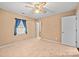 Cozy bedroom featuring neutral carpet, a ceiling fan, a window with blue curtains, and a closet at 322 Cottonwood Park Dr, Charlotte, NC 28214