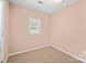 Cozy bedroom featuring neutral paint and carpet, with window providing ample natural light at 322 Cottonwood Park Dr, Charlotte, NC 28214