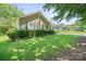 Single-story home with mature landscaping, green grass, and other similar styled homes in background at 322 Cottonwood Park Dr, Charlotte, NC 28214