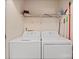 Laundry room with white washer and dryer units under wire shelf and various cleaning supplies at 322 Cottonwood Park Dr, Charlotte, NC 28214